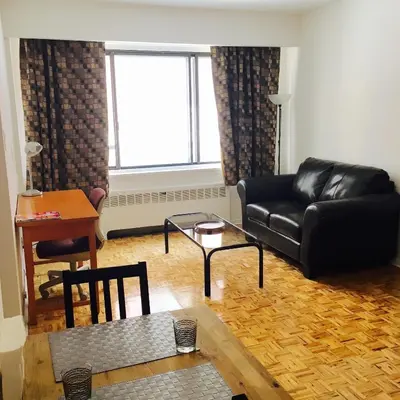 a living room with a black leather couch and a table at Stylish Montreal Apartment Comfortable Stay in the Golden Square Mile in Montréal