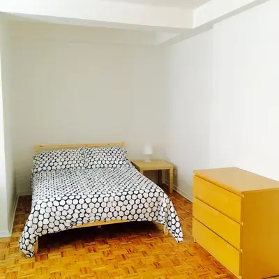 a bedroom with a bed and a wooden dresser at Stylish Montreal Apartment Comfortable Stay in the Golden Square Mile in Montréal