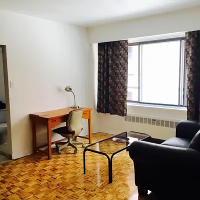 a living room with a desk and a chair and a table at Stylish Montreal Apartment Comfortable Stay in the Golden Square Mile in Montréal