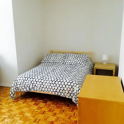 a bedroom with a bed and a wooden floor at Stylish Montreal Apartment Comfortable Stay in the Golden Square Mile in Montréal