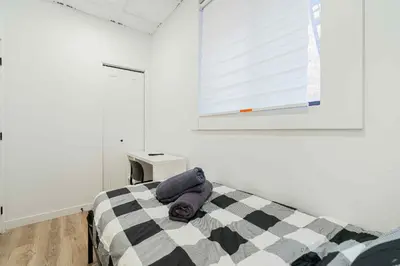 a bedroom with a black and white bed and a window at Room n6-Apartment 1 in a SHARED apartment in downtown Montreal in Montréal