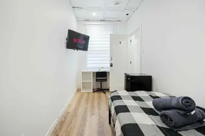 a bedroom with a bed and a tv on the wall at Room in montreal in Montréal