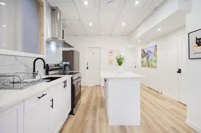 a kitchen with white cabinets and a white counter top at Room in montreal in Montréal