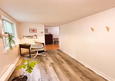 an empty living room with a table and a chair at House 5 bedrooms - close to metro in Montréal