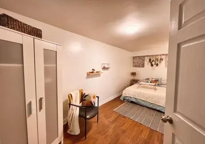a bedroom with a bed and a chair in a room at House 5 bedrooms - close to metro in Montréal