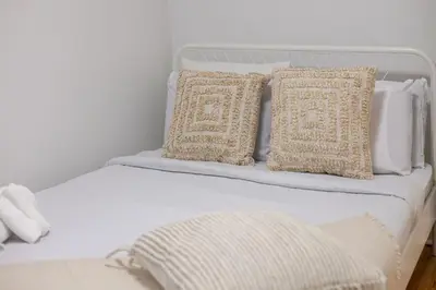 a white bed with two pillows on top of it at Charming 2BR in Plateau Mont-Royal in Montréal