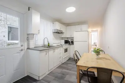 a kitchen with white cabinets and a table with chairs at Charming 2BR in Plateau Mont-Royal in Montréal