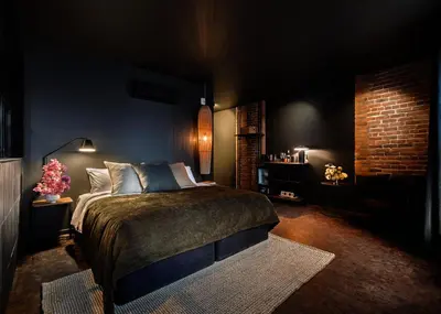 a bedroom with a bed and a brick wall at Maison Grinder in Montréal