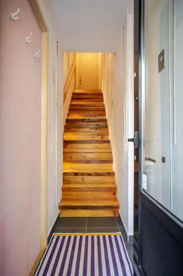a hallway with wooden stairs and a purple floor at Bel appartement confortable - Emplacement idéal in Montréal