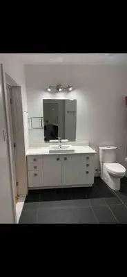 a bathroom with a sink and a toilet and a mirror at Condo spacieux in Montréal