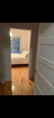 a bedroom with a bed and a door with a mirror at Condo spacieux in Montréal