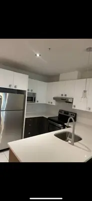 a kitchen with a sink and a stainless steel refrigerator at Condo spacieux in Montréal
