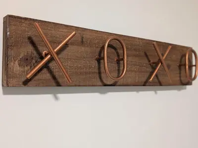 a wooden clock with four wooden sticks on it at Espace Cozy - 2 bed in Longueuil