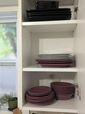 a shelf with plates and dishes on it at Espace Cozy - 2 bed in Longueuil