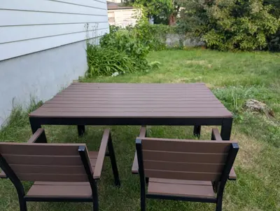 a wooden picnic table and two chairs in a yard at Espace Cozy - 2 bed in Longueuil