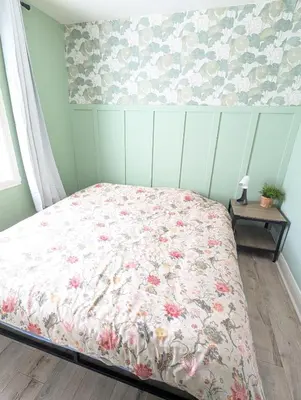 a bedroom with a bed with a floral bedspread at Espace Cozy - 2 bed in Longueuil