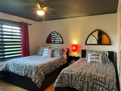 a bedroom with two beds and a ceiling fan at Auberge La Table d'Hôte in West Brome