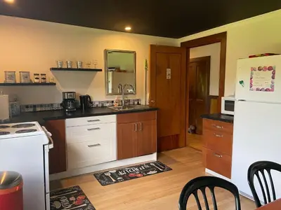a kitchen with a sink and a white refrigerator at Auberge La Table d'Hôte in West Brome