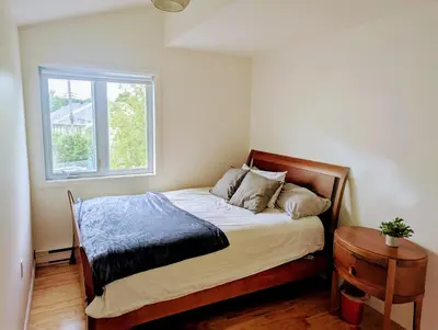 a small bedroom with a bed with a window at Fully furnished cozy home in Montréal