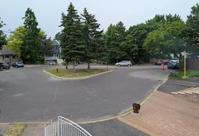 an empty parking lot with cars parked in a driveway at Fully furnished cozy home in Montréal