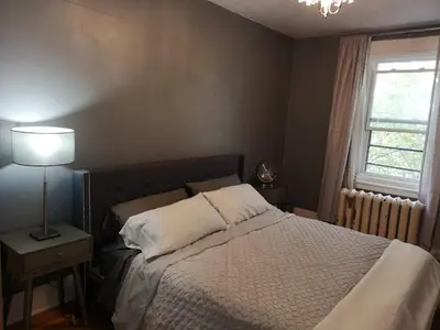 a bedroom with a bed with a lamp and a window at Huge King Room in 3 BedRoom Great Location Downtown Mtl in Montréal