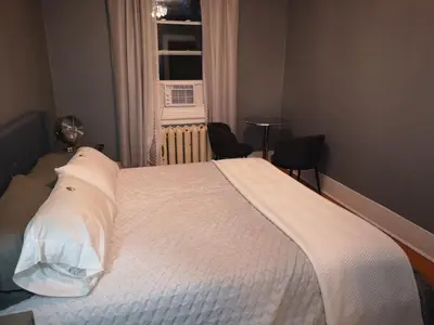 a bedroom with a bed with white sheets and a window at Huge King Room in 3 BedRoom Great Location Downtown Mtl in Montréal