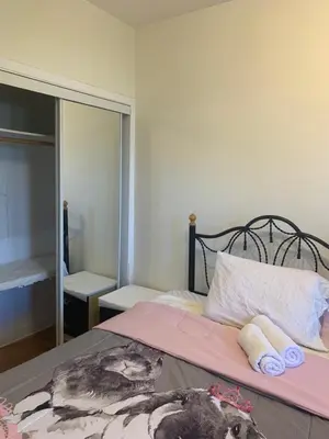 a bedroom with a bed with pink sheets and a mirror at Montreal Accommodation Steps Downtown 17mins airport in Montréal