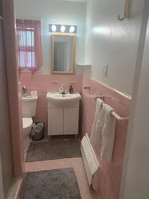 a pink bathroom with a sink and a toilet at Montreal Accommodation Steps Downtown 17mins airport in Montréal