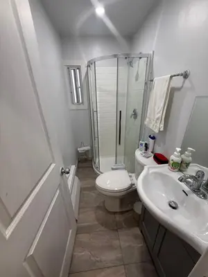 a bathroom with a shower and a toilet and a sink at Montreal Accommodation Steps Downtown 17mins airport in Montréal