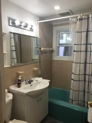 a bathroom with a sink and a toilet and a shower at Montreal Accommodation Steps Downtown 17mins airport in Montréal