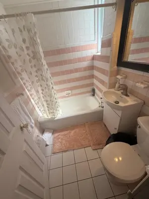 a bathroom with a tub and a toilet and a sink at Montreal Accommodation Steps Downtown 17mins airport in Montréal
