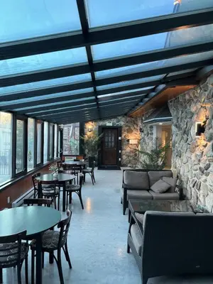 a restaurant with tables and couches and a stone wall at Le loft Orford Magog in Magog-Orford
