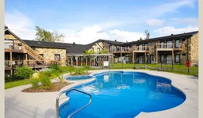 a large swimming pool in front of a building at Le loft Orford Magog in Magog-Orford