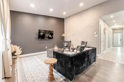 a living room with a black couch and chairs at Bohemian vibe 2 bedroom Free Parking Brand New in Montréal