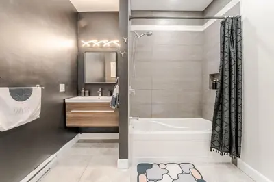 a bathroom with a tub and a shower and a sink at Bohemian vibe 2 bedroom Free Parking Brand New in Montréal