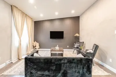 a living room with a couch and chairs and a tv at Bohemian vibe 2 bedroom Free Parking Brand New in Montréal