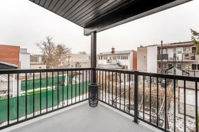 an apartment balcony with a view of a construction at Bohemian vibe 2 bedroom Free Parking Brand New in Montréal