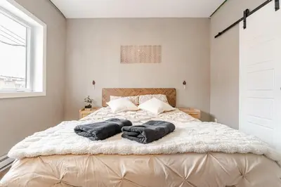 a bedroom with a bed with two towels on it at Bohemian vibe 2 bedroom Free Parking Brand New in Montréal