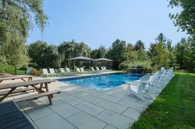 a pool with a bunch of chairs and a table at room with shared bathrooms 883 Shefford in Bromont