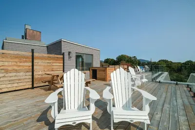 a row of white chairs sitting on a deck at room with shared bathrooms 883 Shefford in Bromont