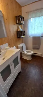 a bathroom with a white toilet and a sink at La détente in Disraeli