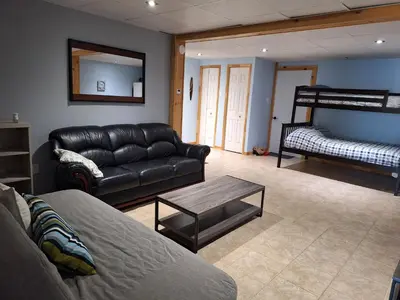 a living room with a leather couch and a table at Le Repos Du Lac Aylmer in Disraeli