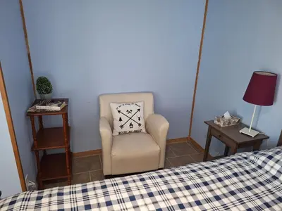 a bedroom with a bed and a chair and a pillow at Le Repos Du Lac Aylmer in Disraeli