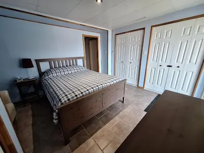 a bedroom with a bed and two white doors at Le Repos Du Lac Aylmer in Disraeli