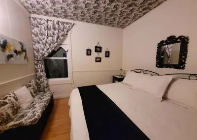 a bedroom with a bed and a window and a couch at Gîte champêtre Chesham in Notre-Dame-Des-Bois