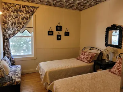 a bedroom with two beds and a window at Gîte champêtre Chesham in Notre-Dame-Des-Bois
