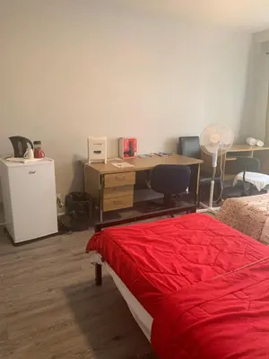 a bedroom with a desk and a bed with a red blanket at Montréal Downtown Private Rooms Across Polytechnique in Montréal