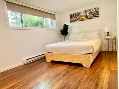 a bedroom with a bed with a wooden floor at Escapade Marie-Isabelle in Montréal
