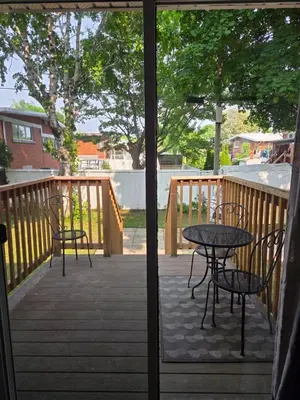 a patio with two chairs and a table on a deck at Escapade Marie-Isabelle in Montréal
