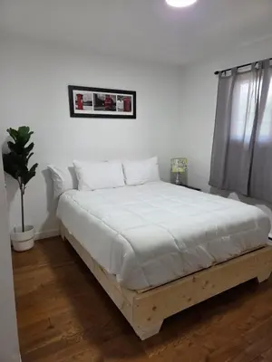 a bedroom with a large bed with white sheets at Escapade Marie-Isabelle in Montréal
